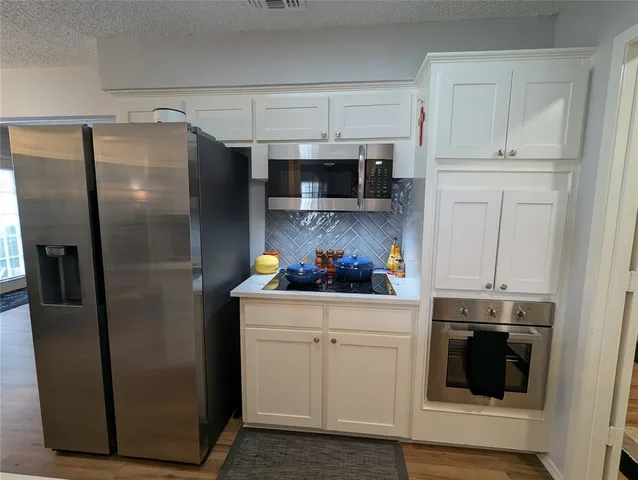 a kitchen with stainless steel appliances a refrigerator and cabinets