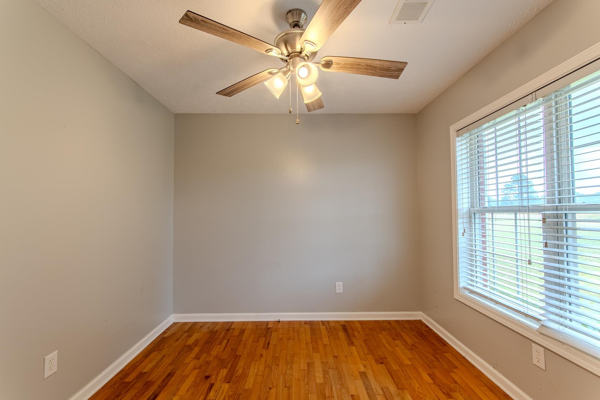 4985 Saltillo Road Saltillo, TN 38370 - Photo 15 of 40 wooden floor in an empty room with a window
