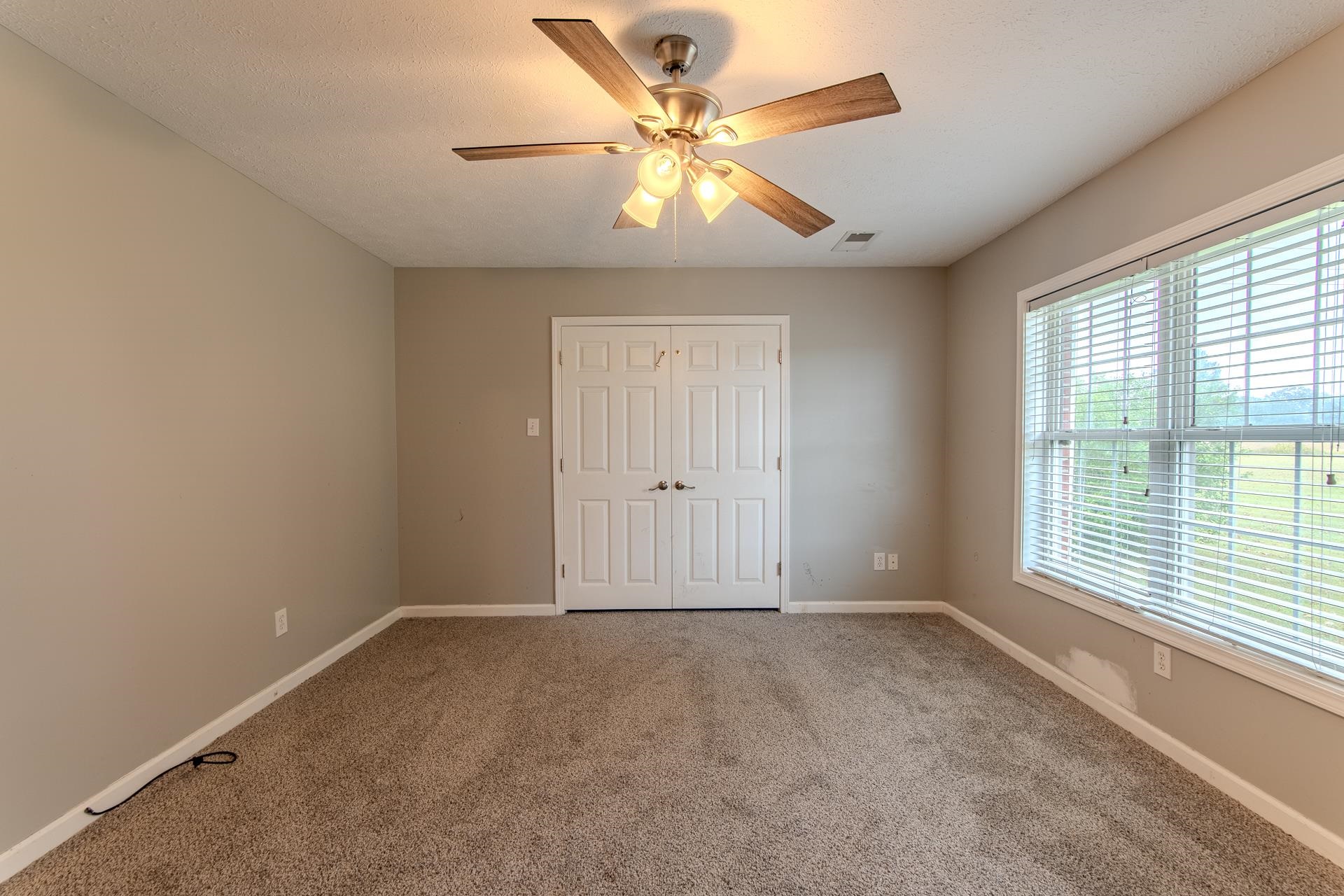 4985 Saltillo Road Saltillo, TN 38370 - Photo 21 of 40 an empty room with chandelier fan and windows