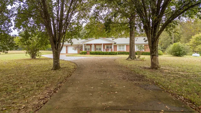 a view of an house with backyard and trees