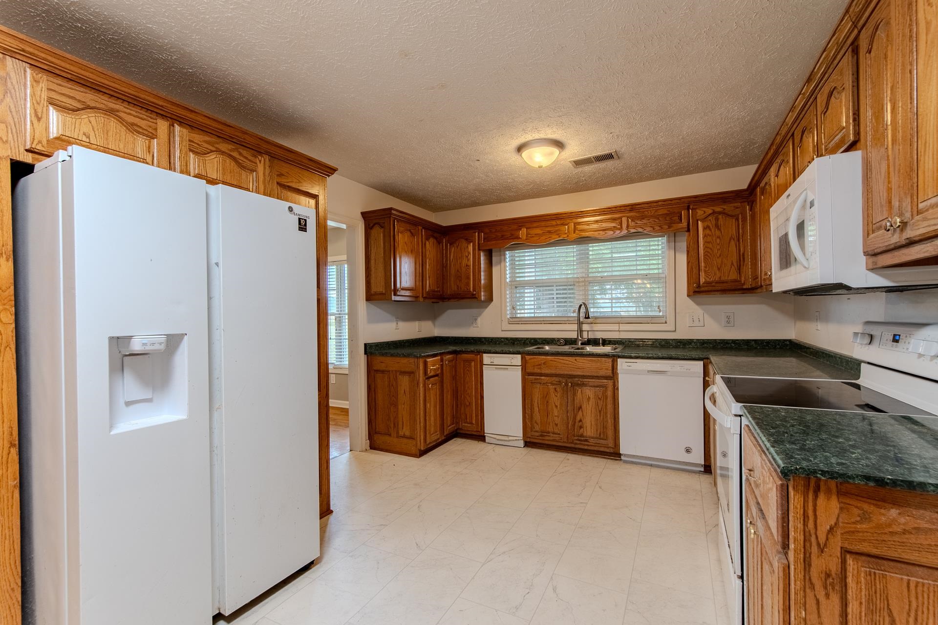 4985 Saltillo Road Saltillo, TN 38370 - Photo 9 of 40 a kitchen with stainless steel appliances granite countertop a refrigerator sink and cabinets
