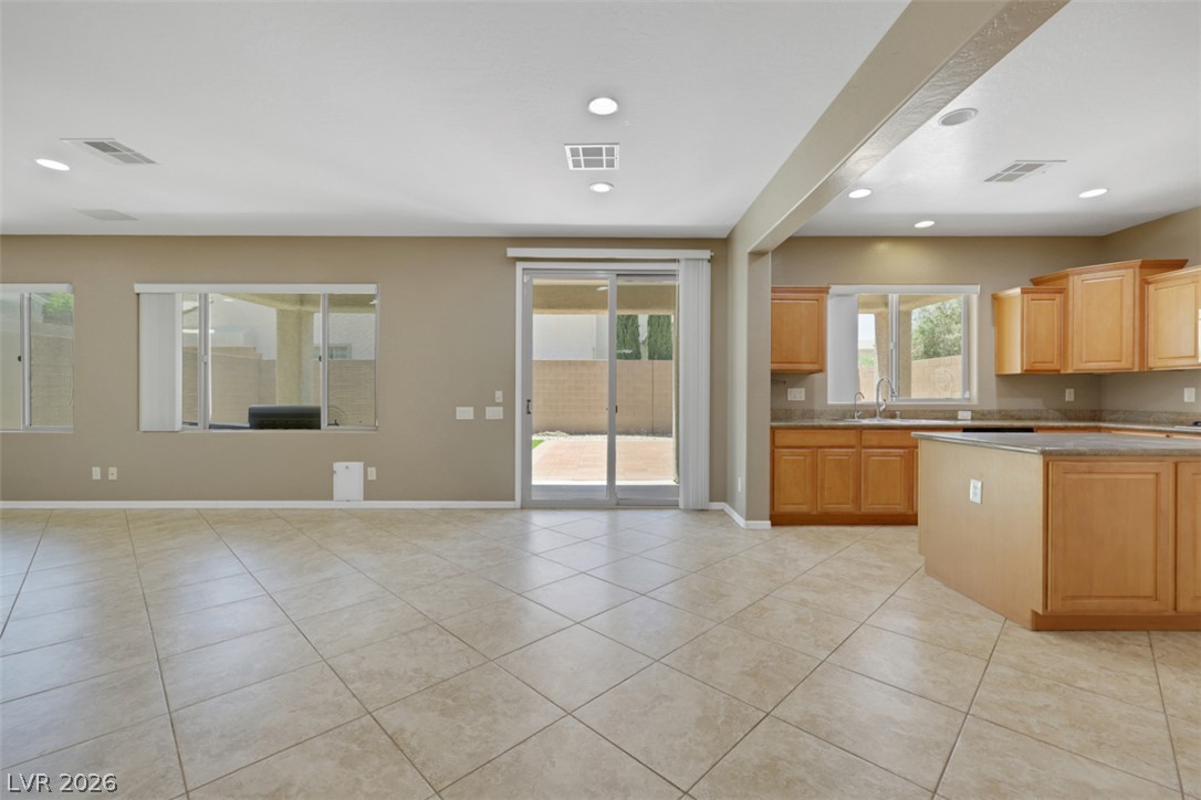 2501 Bechamel Place Henderson, NV 89044 - Photo 49 of 50 An open floorplan seamlessly connects the living space to the kitchen, extending to a private patio.