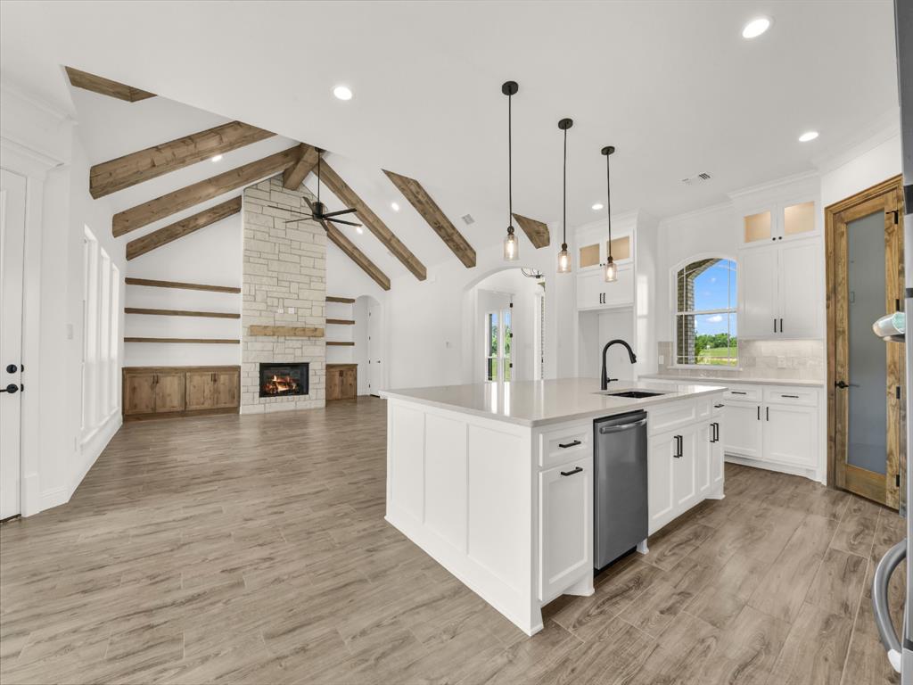 143 Desperado Way Weatherford, TX 76088 - Photo 10 of 36 Kitchen with a sink, a ceiling fan, a center island with sink, recessed lighting, and a fireplace