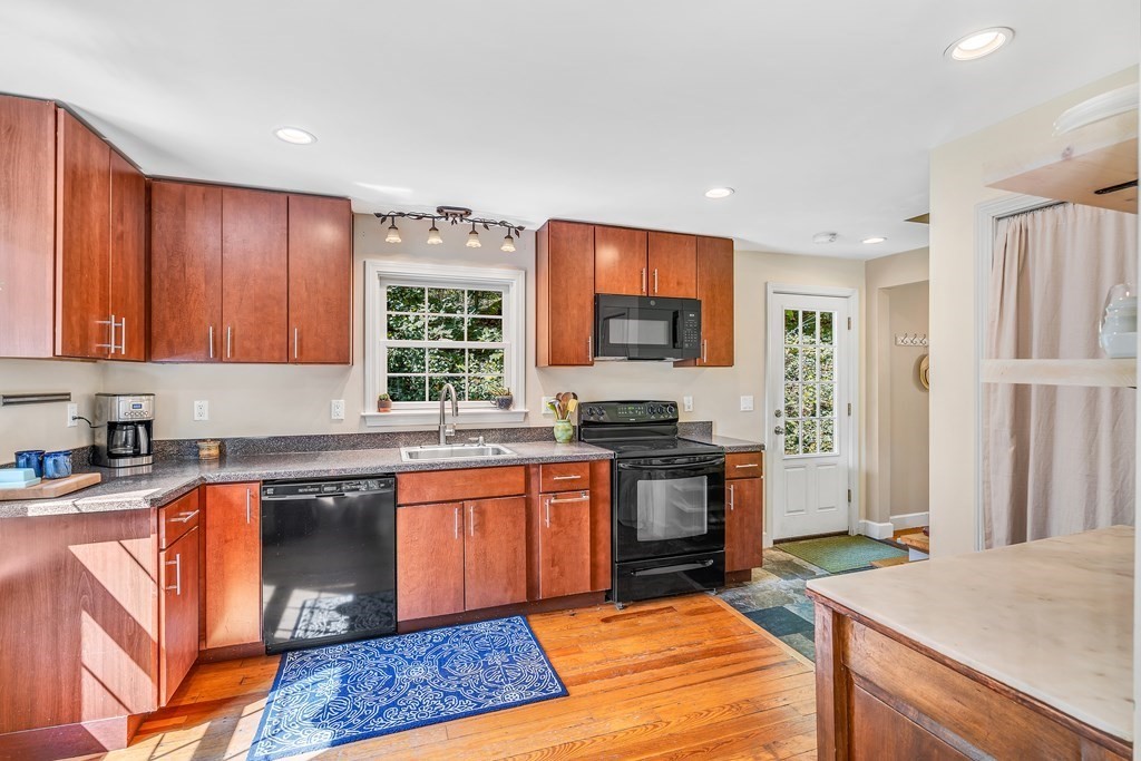 239 Sudbury Road Stow, MA 01775 - Photo 11 of 31 a kitchen with stainless steel appliances granite countertop a stove top oven a sink dishwasher and a refrigerator with wooden cabinets