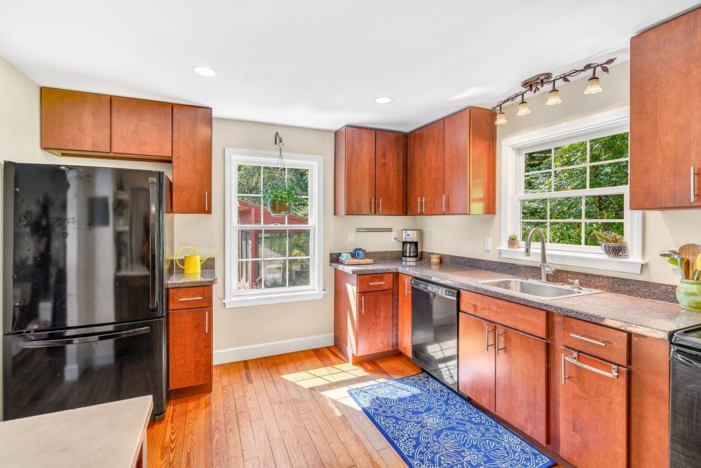 239 Sudbury Road Stow, MA 01775 - Photo 14 of 31 a kitchen with stainless steel appliances granite countertop a refrigerator a sink dishwasher and wooden cabinets with wooden floor