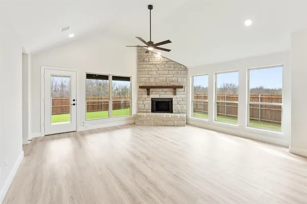 a view of an empty room with a fireplace and a window