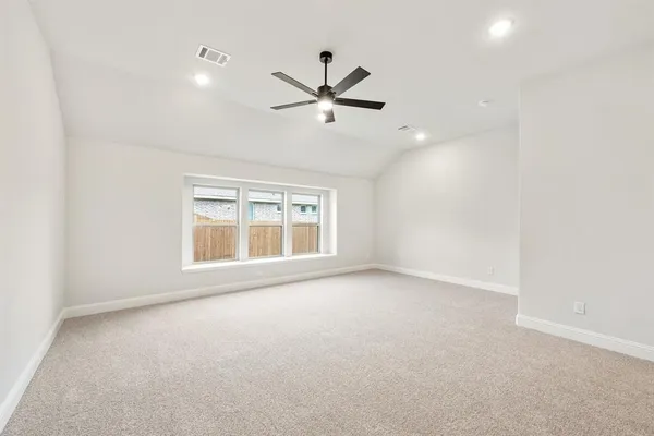 an empty room with a window and a fan