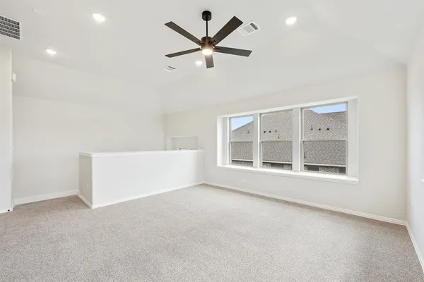 an empty room with a window and a ceiling fan