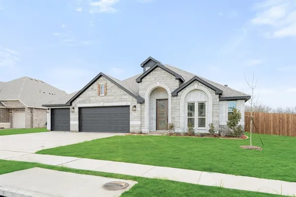 a front view of a house with a garden and yard