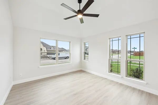 a view of an empty room with a window and wooden floor
