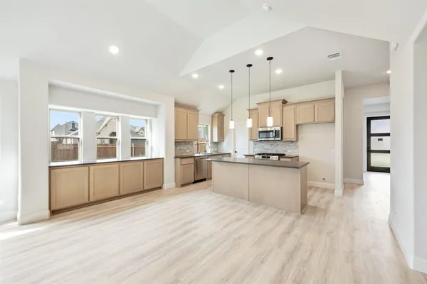 a large kitchen with kitchen island a sink stainless steel appliances and cabinets