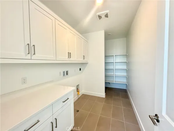 a view of cabinets and utility room with closet