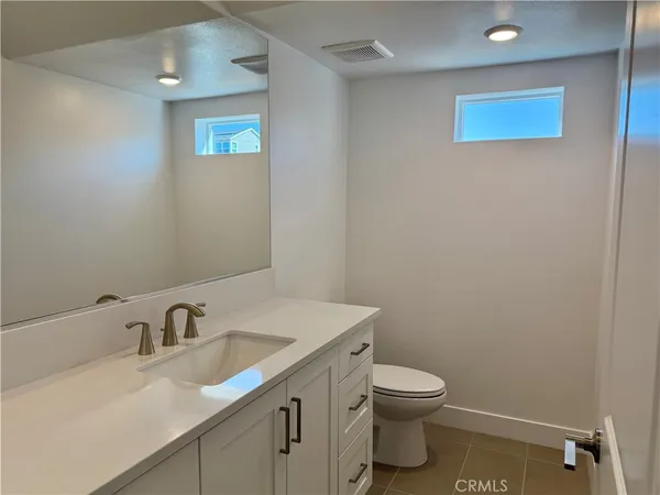 a bathroom with a granite countertop sink a toilet and a mirror