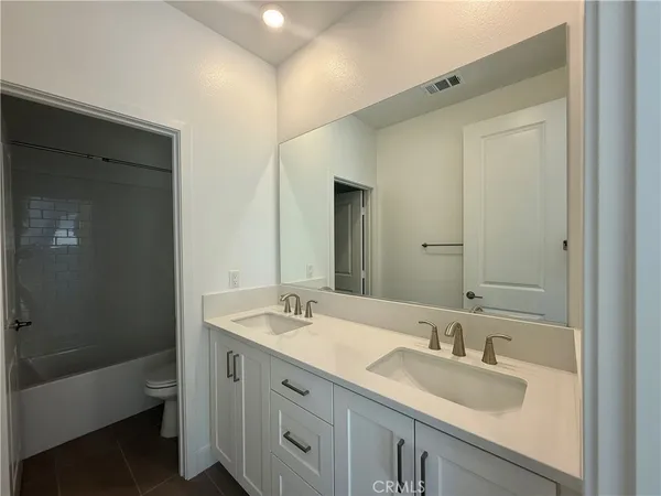 a bathroom with 2 sink tub and a mirror