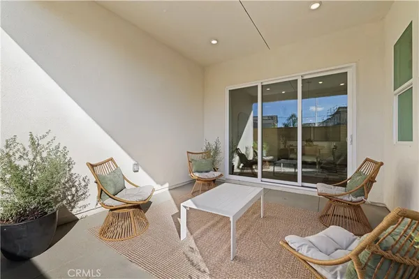 a building outdoor space with patio furniture and potted plants