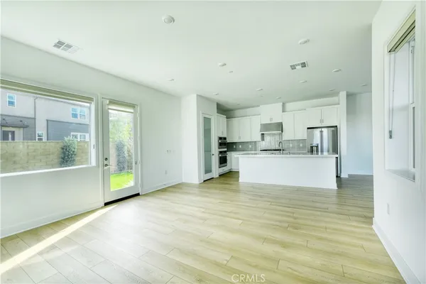 a view of kitchen with wooden floor and electronic appliances