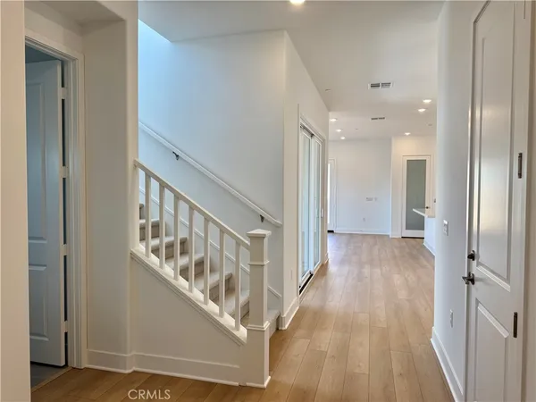 a view of a hallway with wooden floor and staircase