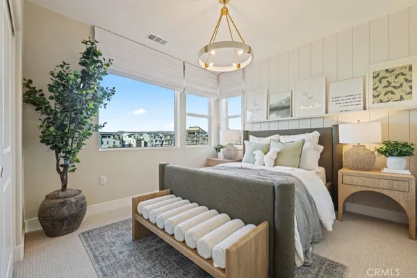 a bedroom with a bed and a chandelier
