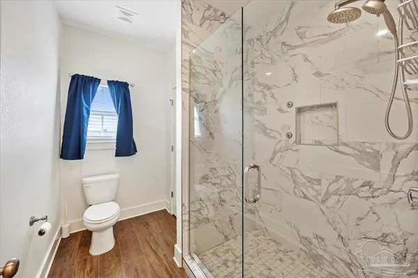 a bathroom with a toilet and a shower