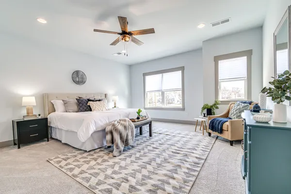 a spacious bathroom with double vanity a toilet a a mirror a bathtub and shower