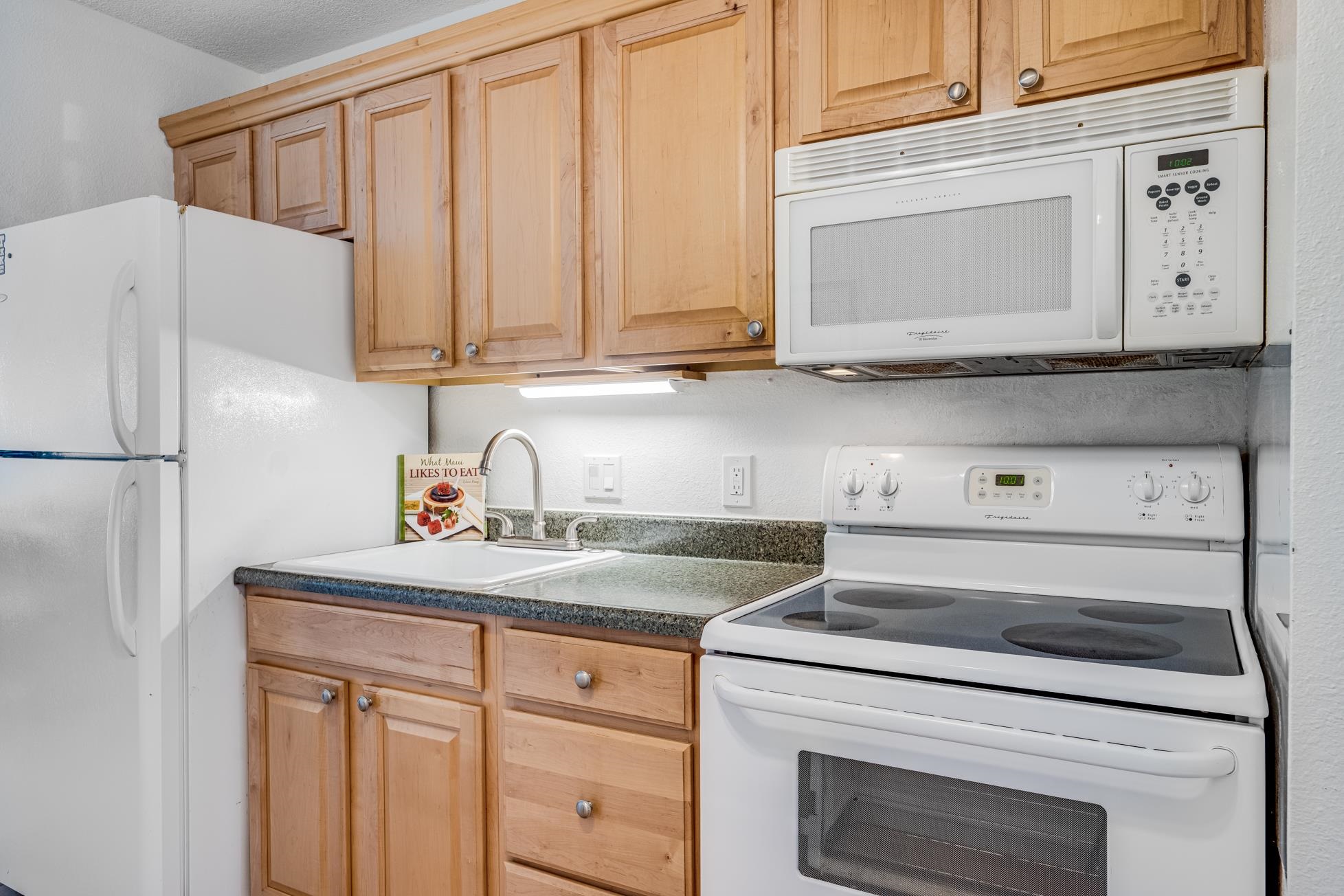 715 South Kihei Road, Unit A207 Kihei, HI 96753 - Photo 15 of 27 a kitchen with granite countertop white cabinets and white appliances