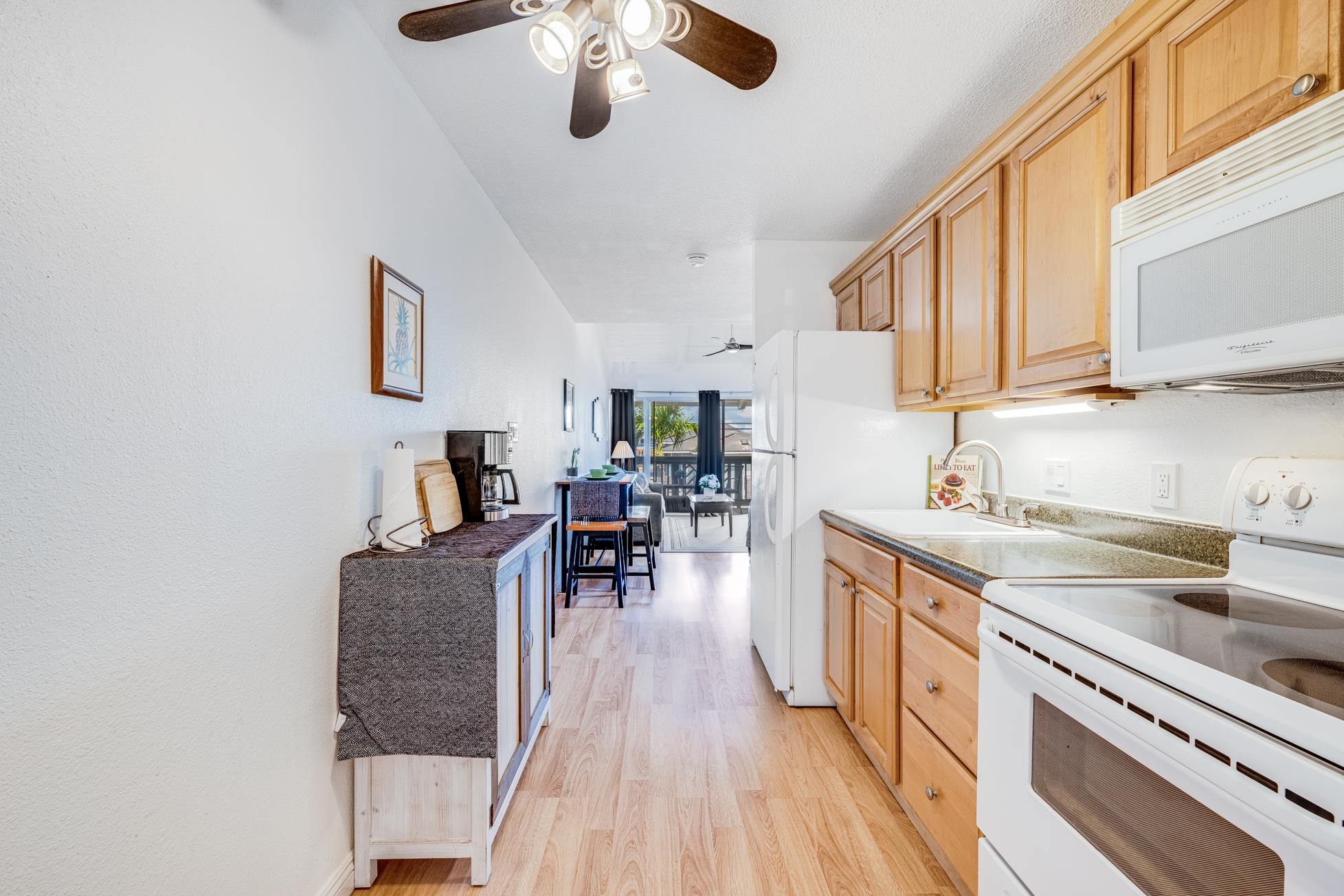 715 South Kihei Road, Unit A207 Kihei, HI 96753 - Photo 6 of 27 a kitchen with stainless steel appliances granite countertop a lot of counter space and wooden floors