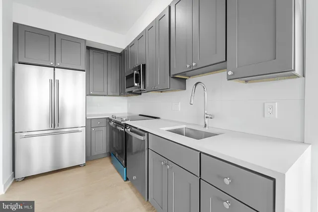 a kitchen with a sink a refrigerator and cabinets