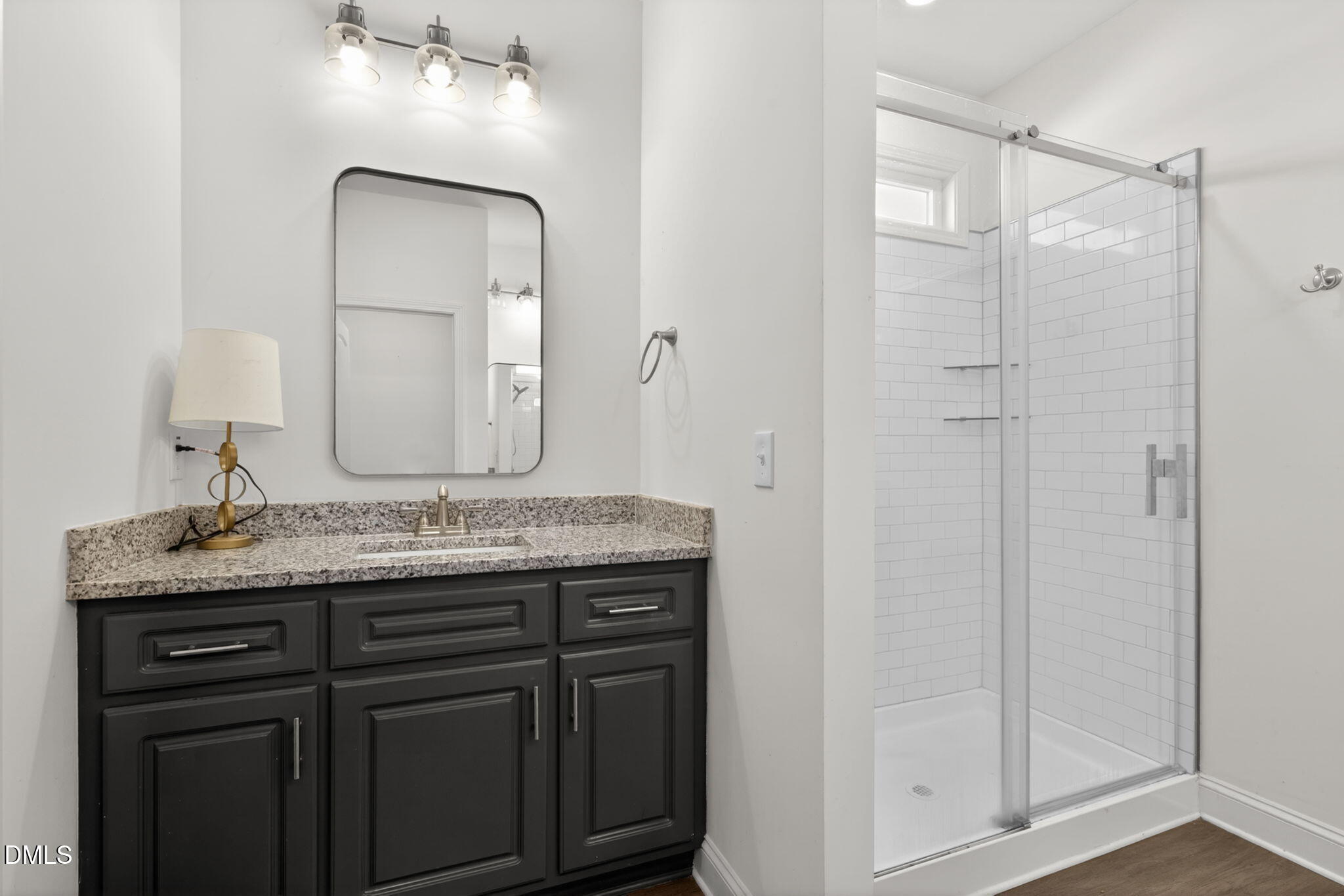 9084 Byron Court Bailey, NC 27807 - Photo 20 of 40 a bathroom with a granite countertop sink a mirror and a shower
