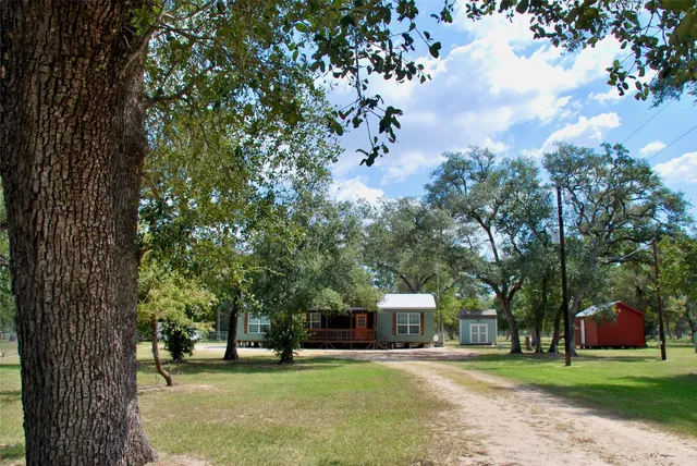 a front view of a house with a yard and tree s