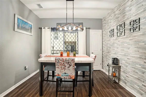 a dining room with furniture a chandelier and wooden floor