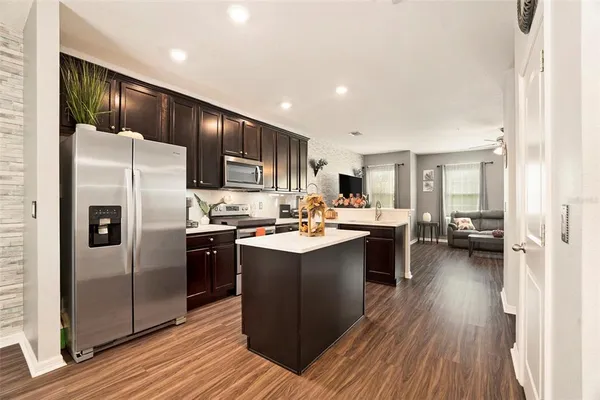 a kitchen with a sink refrigerator and cabinets
