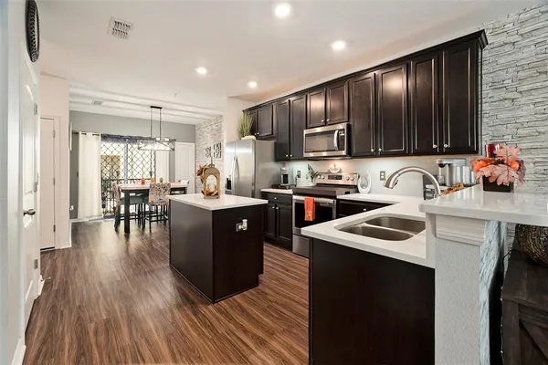 a kitchen with stainless steel appliances granite countertop wooden cabinets a stove top oven a sink and dishwasher