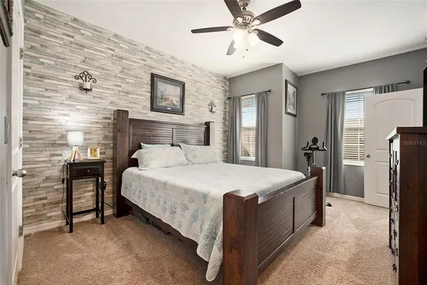 a spacious bedroom with a bed and a chandelier