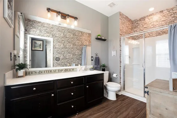 a bathroom with a double vanity sink toilet mirror and shower