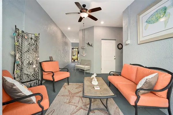 a living room with furniture a ceiling fan and a rug