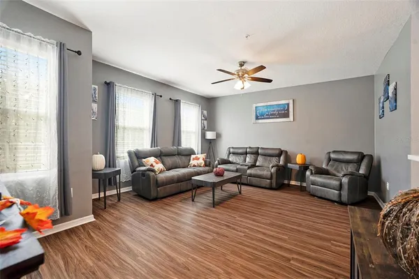 a living room with furniture and a wooden floor