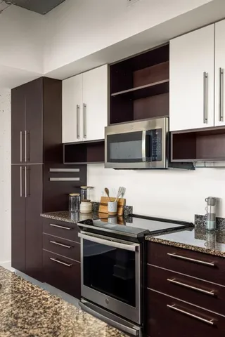 a kitchen with stainless steel appliances granite countertop a stove microwave and refrigerator