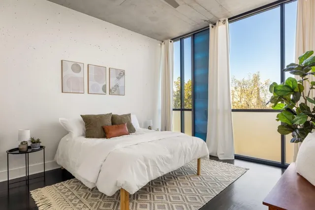 a bedroom with a large bed and a potted plant