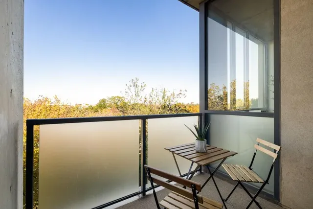 a view of a balcony with furniture and next to a window
