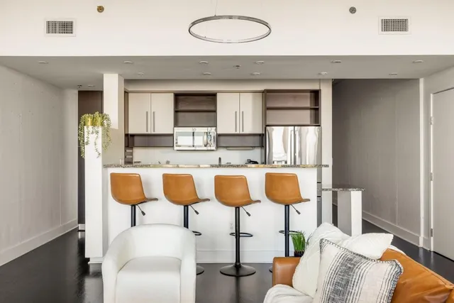 a living room with kitchen island granite countertop furniture a sink and a window
