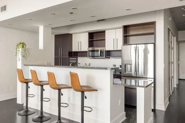 a kitchen with stainless steel appliances granite countertop a refrigerator and microwave