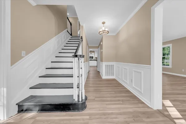a view of entryway and hall with wooden floor