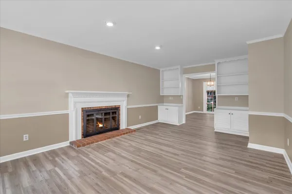 a view of empty room with wooden floor and fireplace
