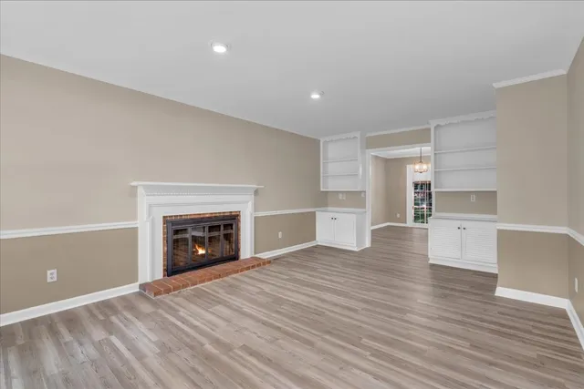 a view of empty room with wooden floor and fireplace