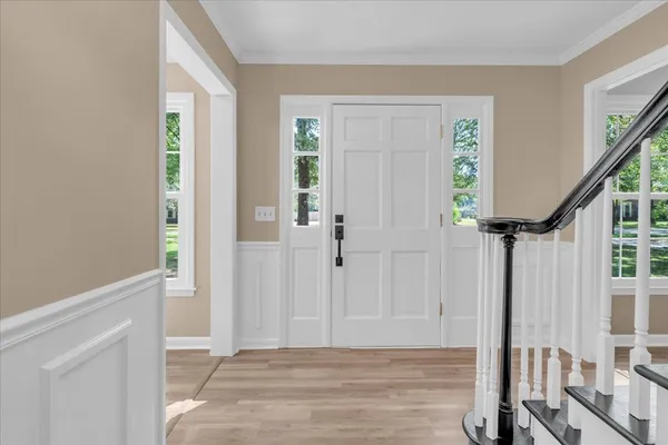 a view of an entryway with wooden floor and door