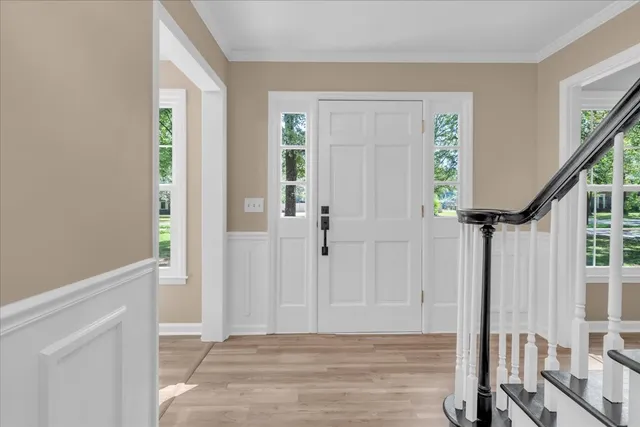 a view of an entryway with wooden floor and door