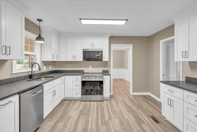 a kitchen with granite countertop a sink stove and cabinets