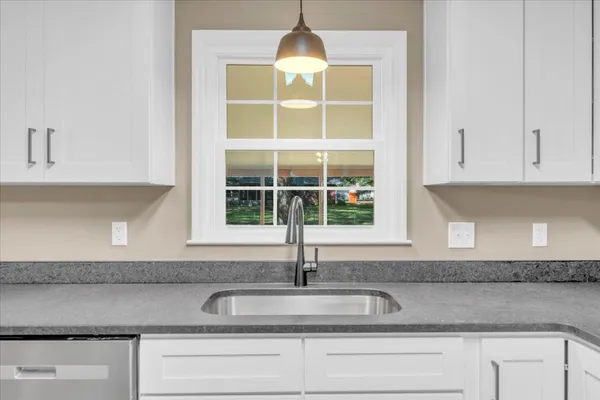 a kitchen with granite countertop a sink and cabinets