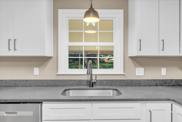 a kitchen with granite countertop a sink and cabinets