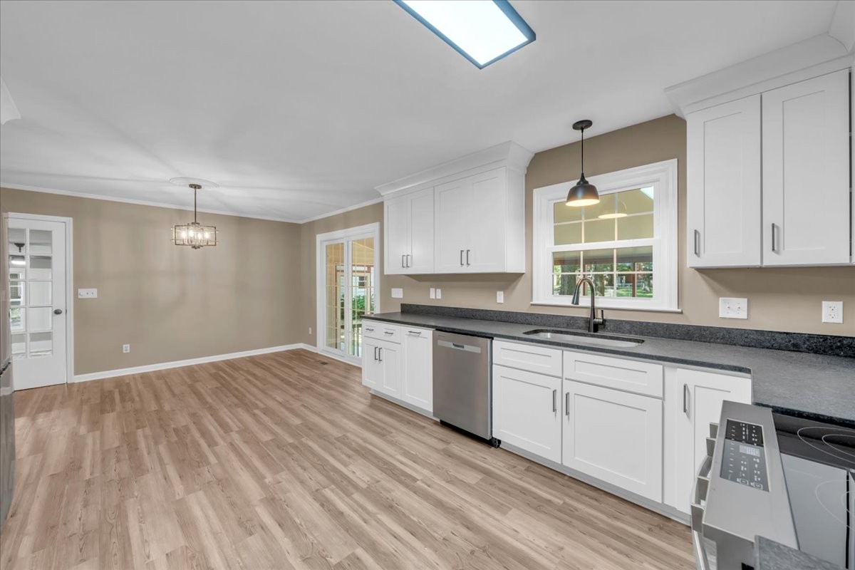 302 Marbeth Lane Tullahoma, TN 37388 - Photo 28 of 50 a kitchen with granite countertop a stove a sink and white cabinets with wooden floor